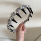 Gifty fluffy headband styled with matching accessories on wooden surface