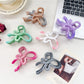 Close-up of Beau ombre heart shaped bow claw clip showing gradient colors and clasp detail