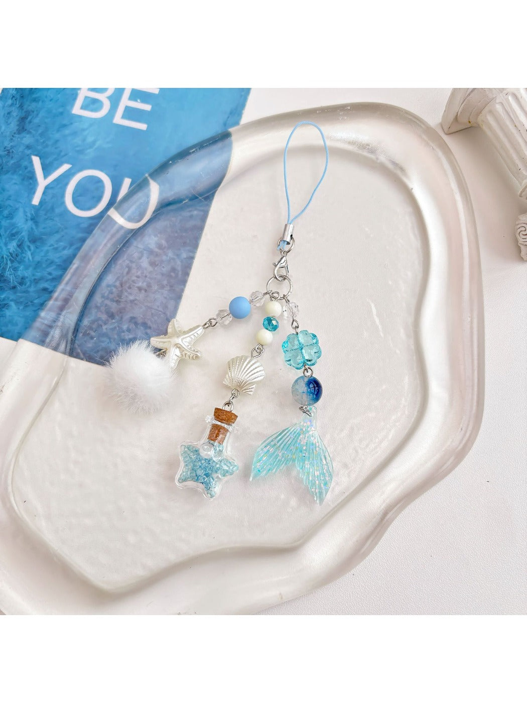 Blue glass drift bottle keychain displayed on a white background