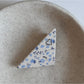 Beau hair clip placed on white surface showing star pattern and glossy finish