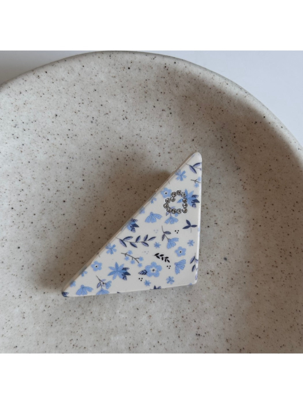 Beau hair clip placed on white surface showing star pattern and glossy finish