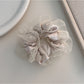 Multiple solid color ruffled scrunchies stacked together showing color variety