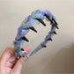 Gifty dainty floral print headband folded to show its lightweight and comfortable fit