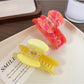 Back view of yellow fruit hair claw clip showing metal spring clasp mechanism