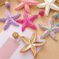 Pair of stylish starfish drop earrings displayed on a white background