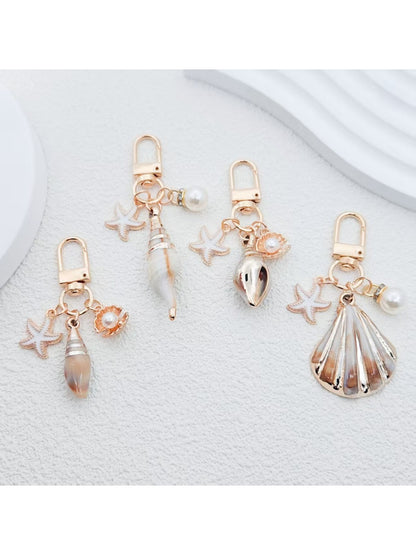 Gold conch shell shaped keychain with smooth polished finish on white background