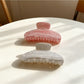 Beau candy color claw clip in pastel blue held in hand