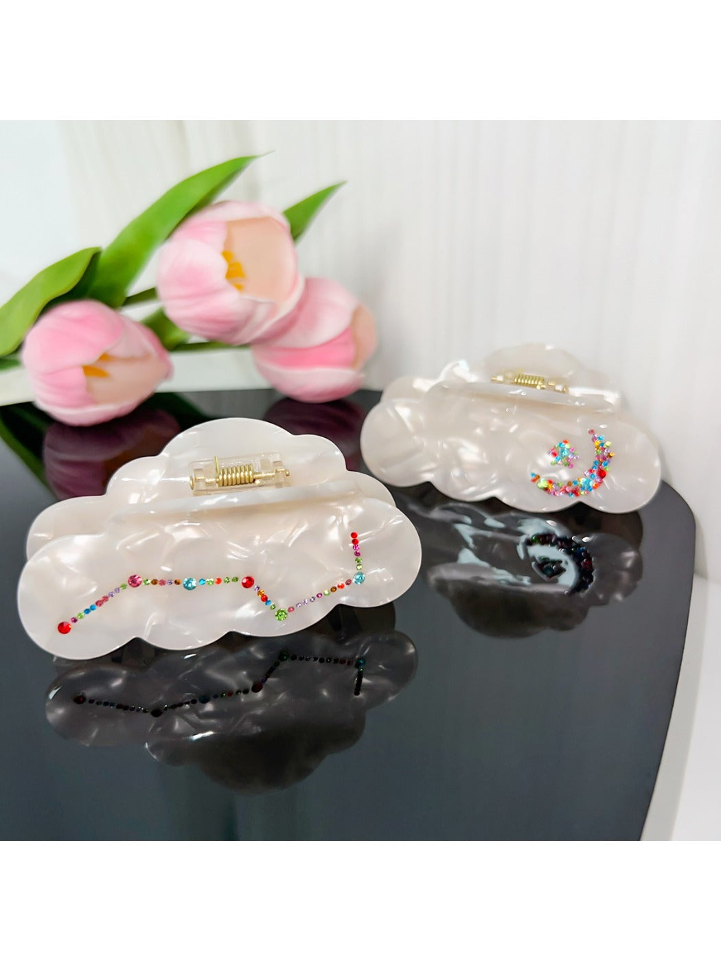 Beau hair claw clip held in hand to show size and cloud shape design