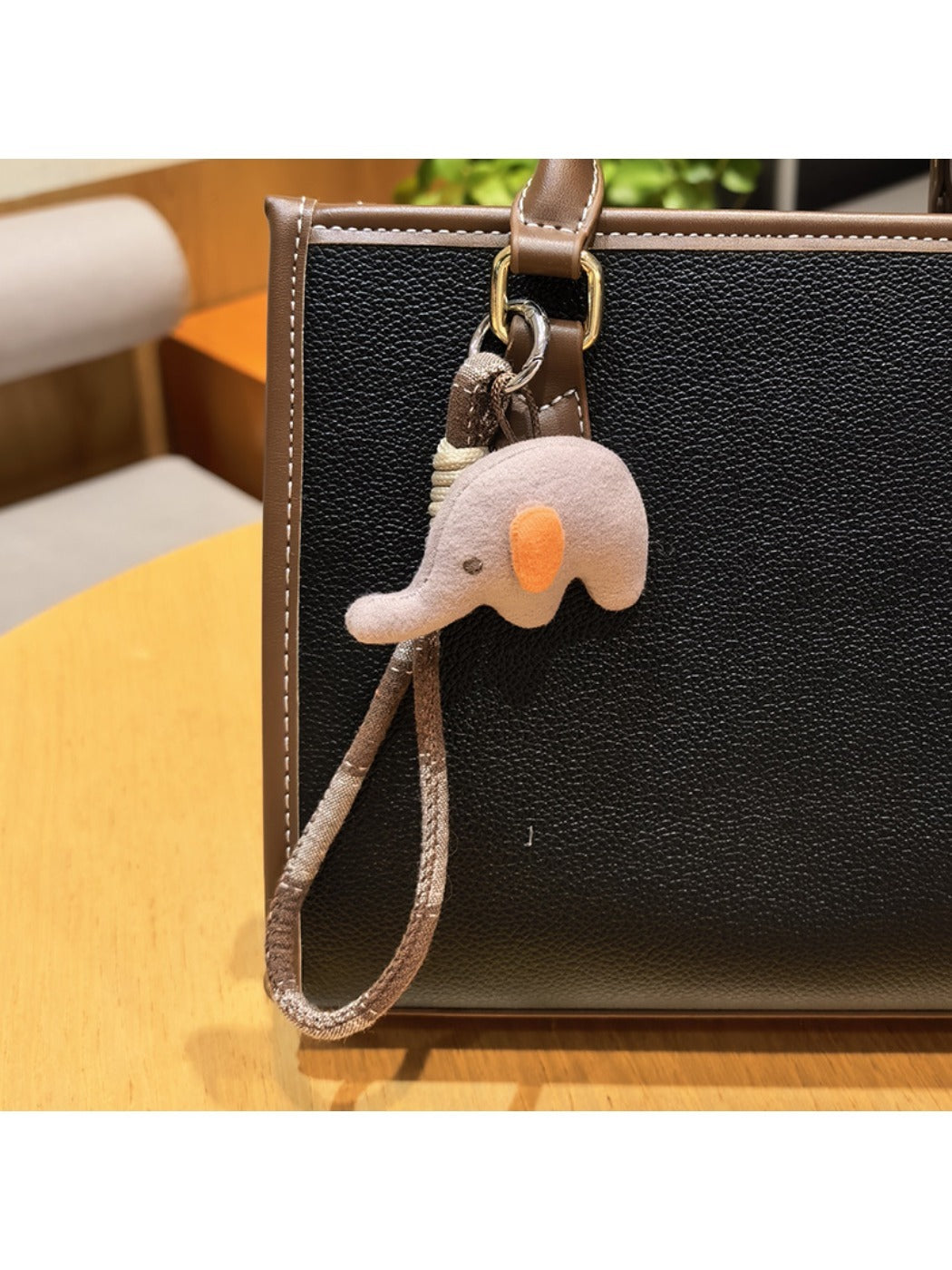 Elephant charm keychain attached to a backpack zipper pull