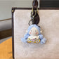 Vintage girl charm keychain displayed with other retro-style accessories on a table