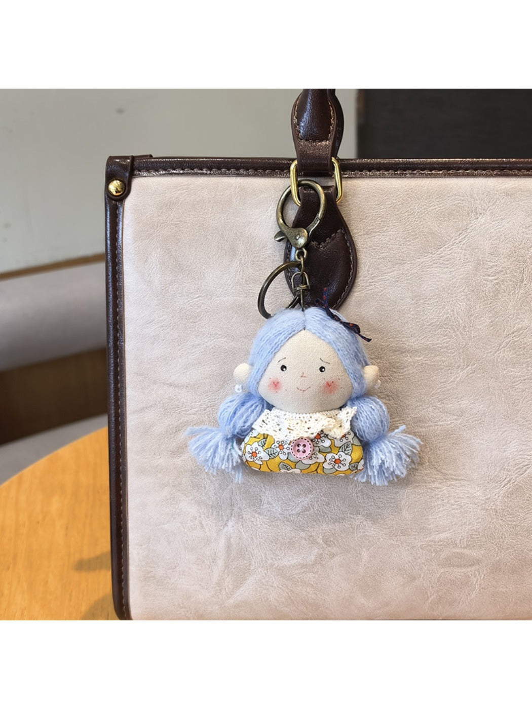 Vintage girl charm keychain displayed with other retro-style accessories on a table