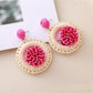 Model wearing Earedge raffia woven earrings showcasing their size and style