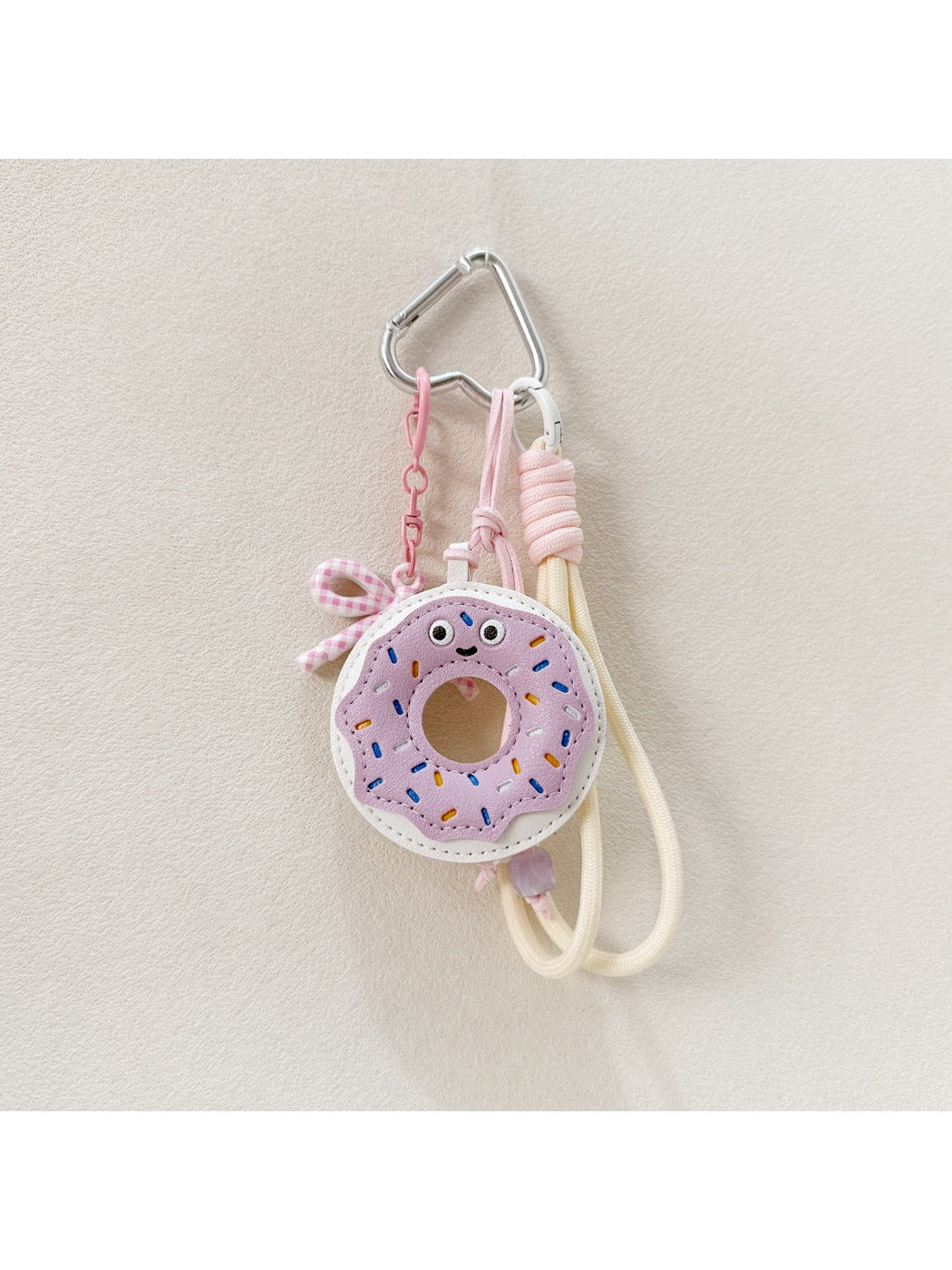 Donut keychain next to a smartphone and wallet on a table