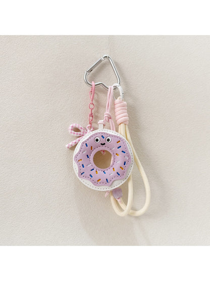 Donut keychain next to a smartphone and wallet on a table