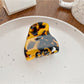Claw clip resting on fabric, highlighting its small size and vibrant colors