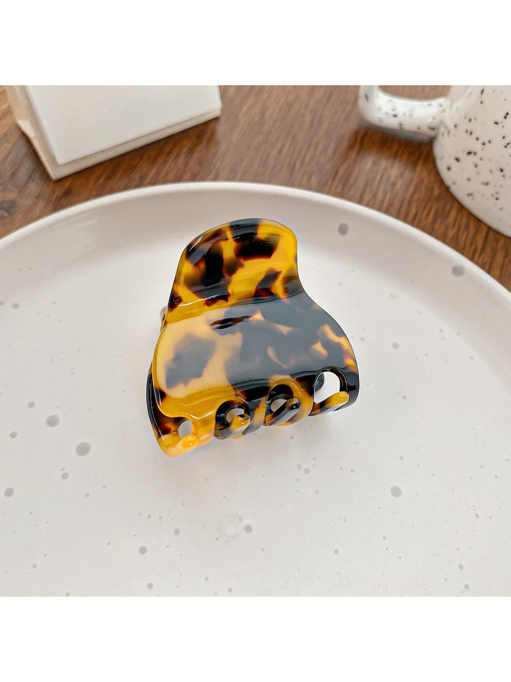 Claw clip resting on fabric, highlighting its small size and vibrant colors