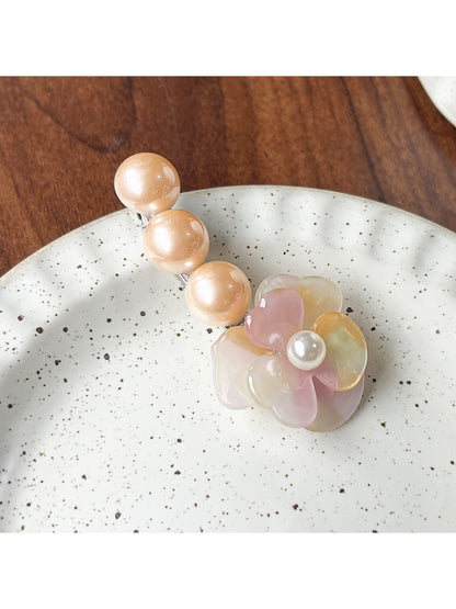 Beau Camellia beaded hair clip shown clipped onto hair strands
