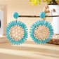 Elegant sunflower shaped drop earrings displayed in a jewelry box