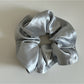 Gifty satin scrunchie paired with other hair accessories on a wooden surface