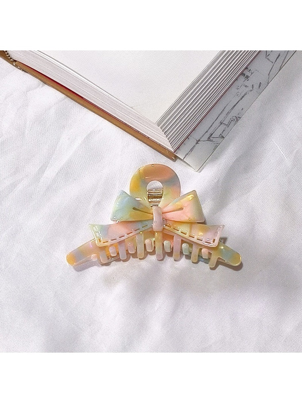 Beau acetate bow shaped claw clip placed on wooden surface