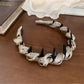 Gifty satin headband folded to display inner lining and polka dot design