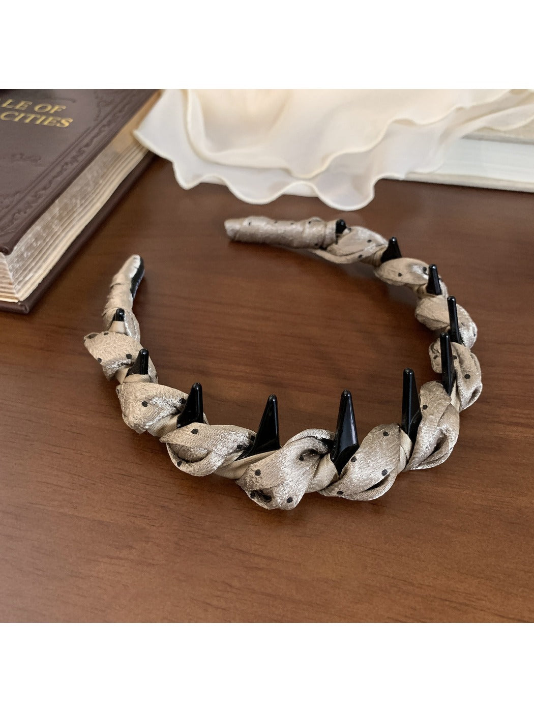 Gifty satin headband folded to display inner lining and polka dot design