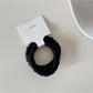Gifty satin hair tie wrapped around wrist as a stylish accessory