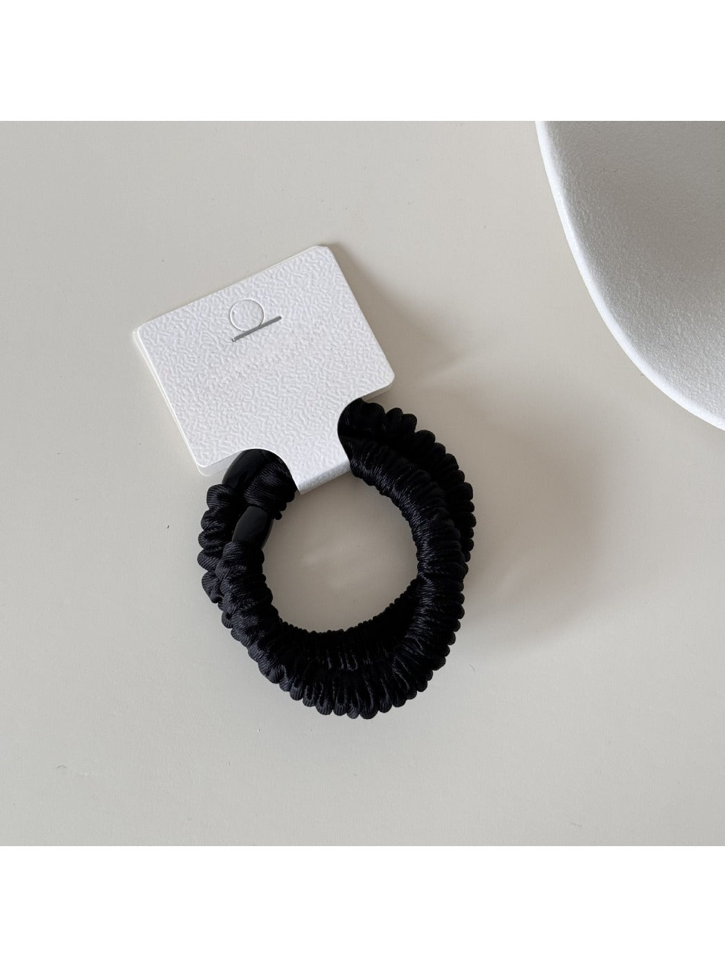 Gifty satin hair tie wrapped around wrist as a stylish accessory
