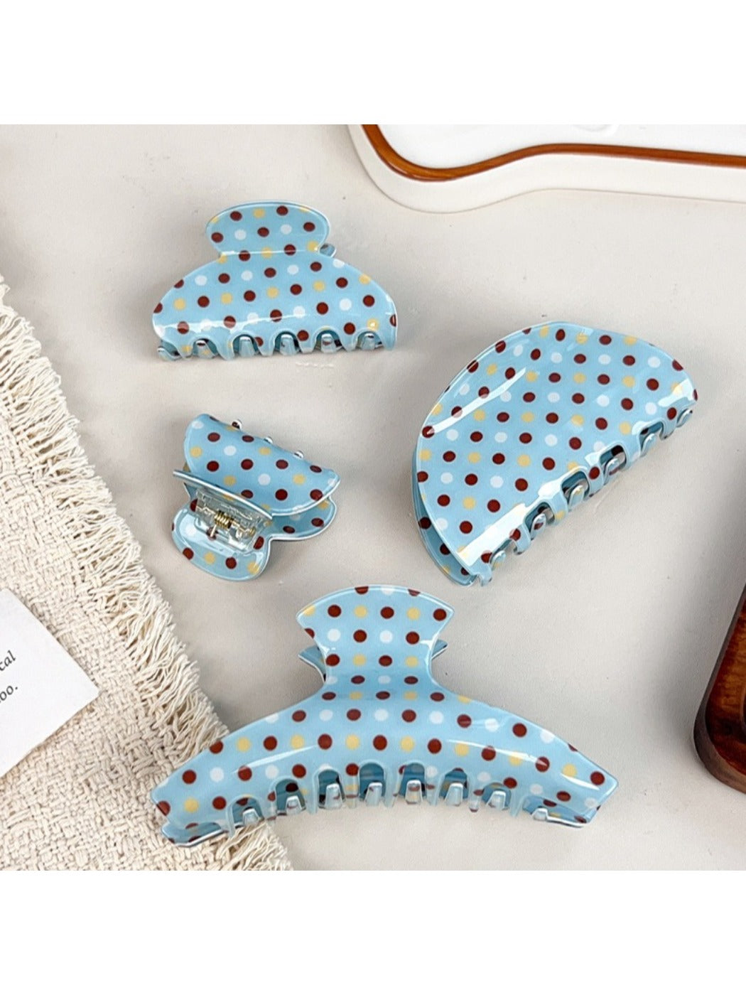 Close-up of blue polka dot hair claw clip showing curved teeth