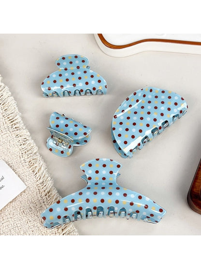 Close-up of blue polka dot hair claw clip showing curved teeth