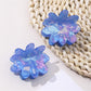Blue flower shaped hair clip with detailed petals on white background