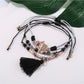 Lovra bracelet with alloy charm and tassel pendant displayed flat