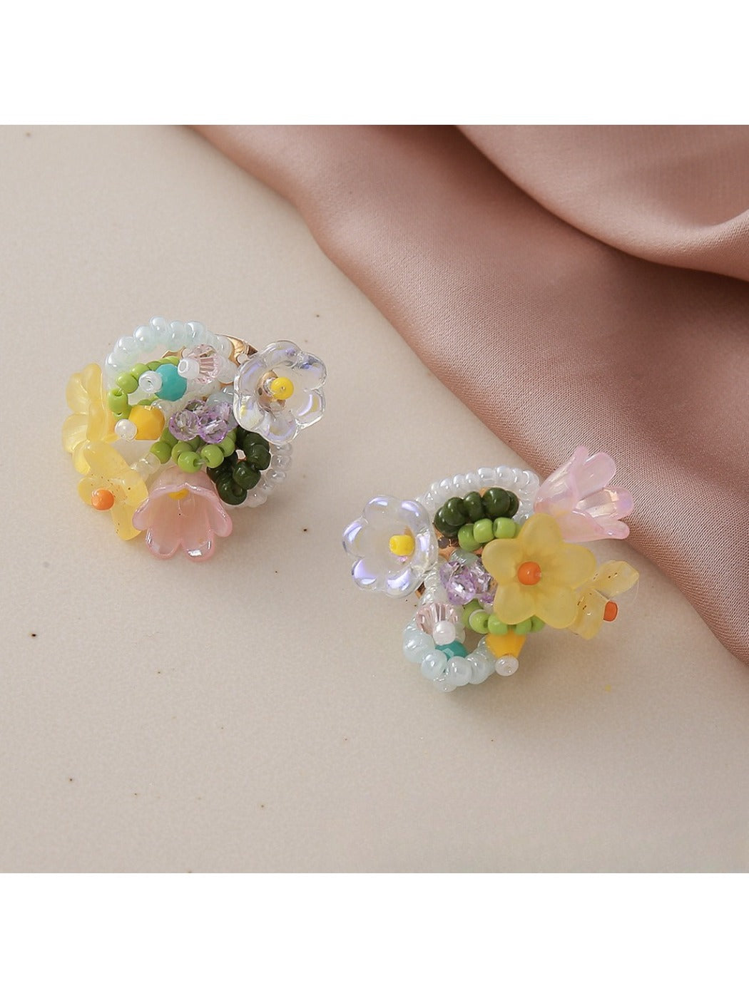 Model wearing small beaded flower-shaped earrings with a casual outfit