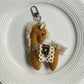 Fabric pony bag charm hanging from a backpack zipper pull