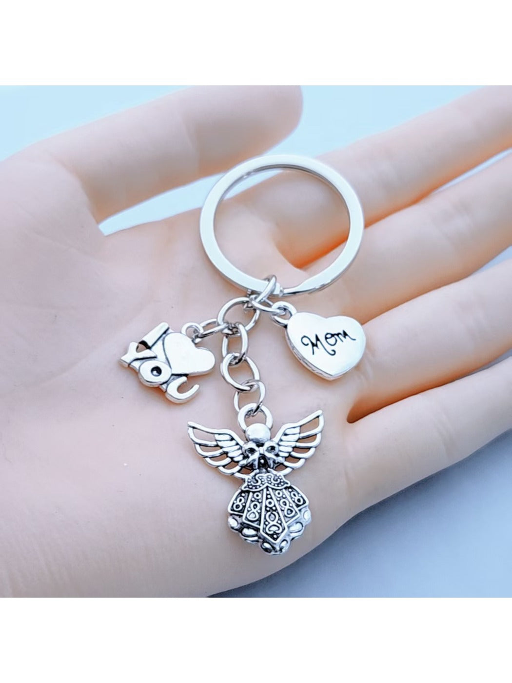 Close-up of alloy angel shaped keychain with detailed wings and halo