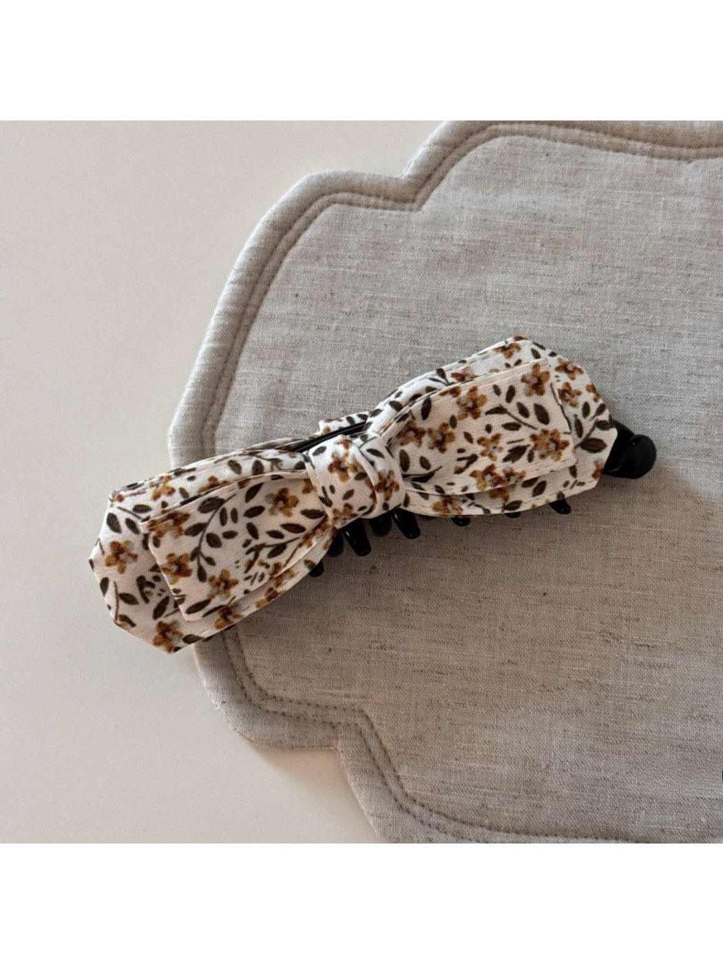 Beau bow hair clip styled in a ponytail, featuring blue and beige oil painting pattern