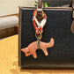 Fox charm keychain next to a small notebook and pen on a desk