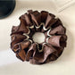 Gifty vintage dark double layered scrunchie displayed on a wooden surface