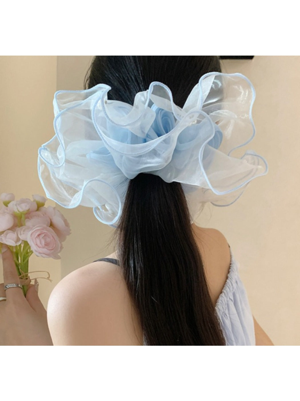 Elegant tulle scrunchie displayed on a wooden surface highlighting its sheer material