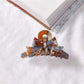 Beau acetate bow shaped claw clip open to show inner teeth and clasp