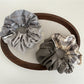 Gifty scrunchie styled on a wrist showing its patchwork plaid design