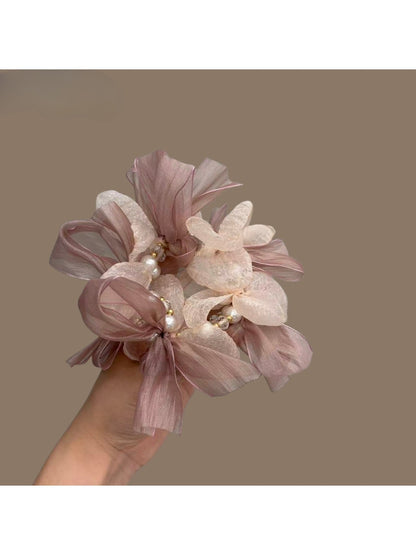 Sweet pink bow scrunchie made of soft fabric, styled on a white background
