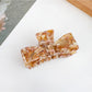 Beau bow shaped claw clip displayed alongside matching hair accessories