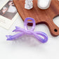 Beau heart shaped bow claw clip clipped into straight hair on a model's side profile