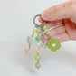 Keypus green beaded keychain hanging from a silver keyring on white background
