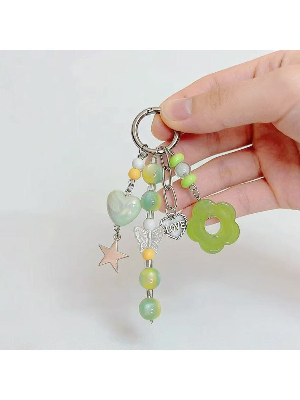 Keypus green beaded keychain hanging from a silver keyring on white background