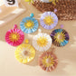 Close-up of Earedge color block sunflower shaped earrings on white background