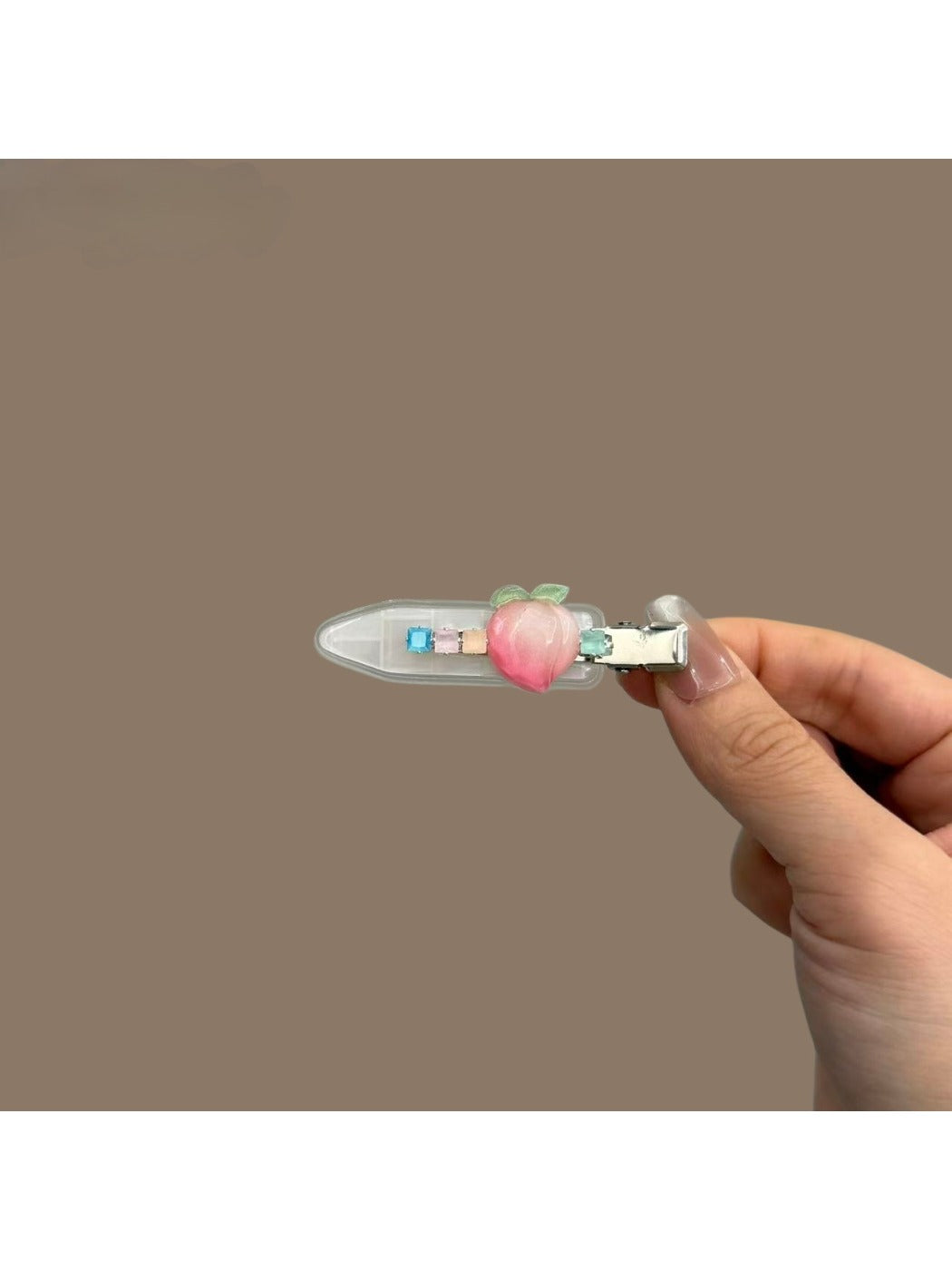 Close-up of Beau hair clip featuring peach illustrations and metal clip