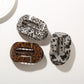 Side view of Beau patterned hair clip highlighting curved shape and clasp mechanism