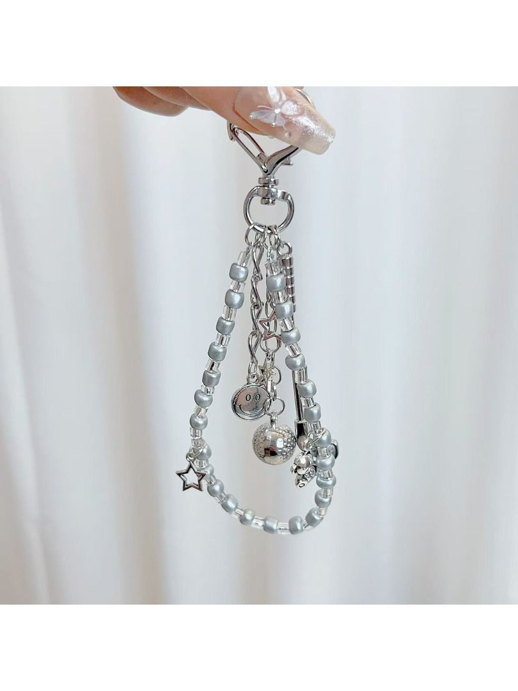 Close-up of textured golf ball charm attached to silver keyring
